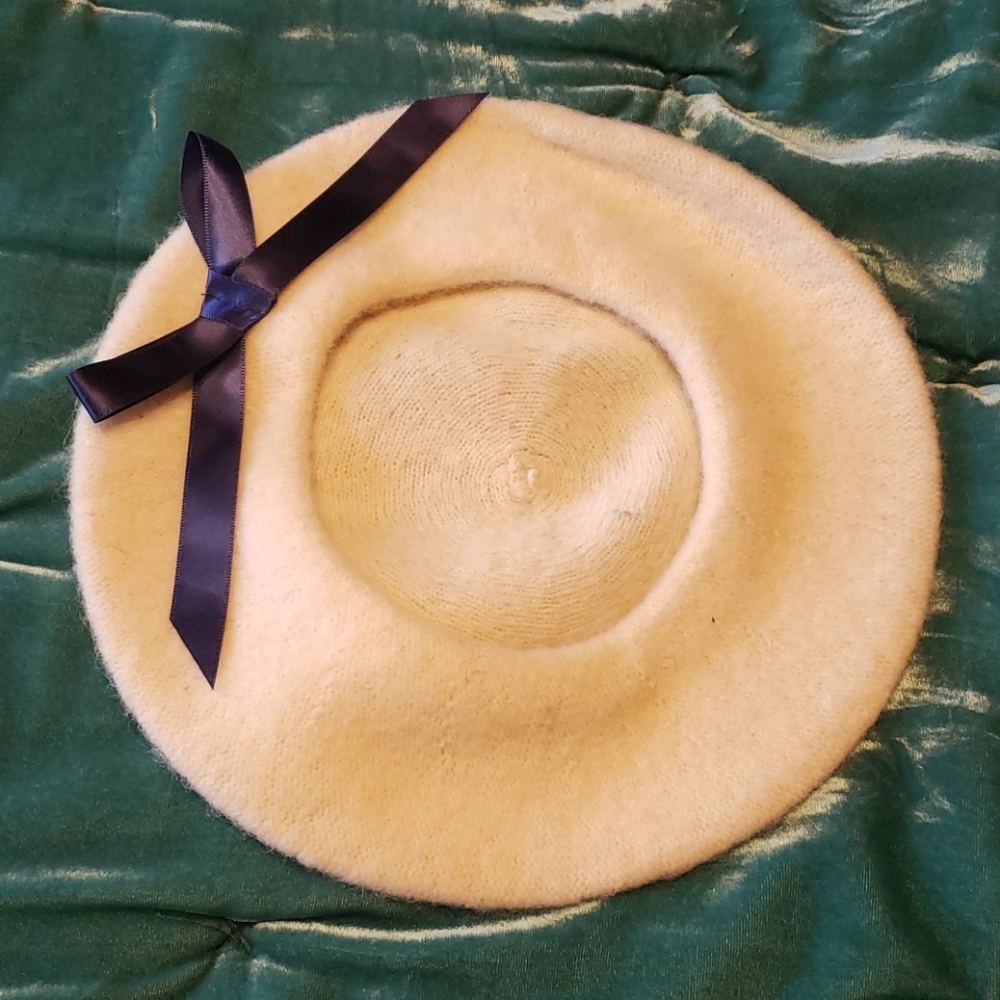 Beret hat. Cream colored with navy blue bow